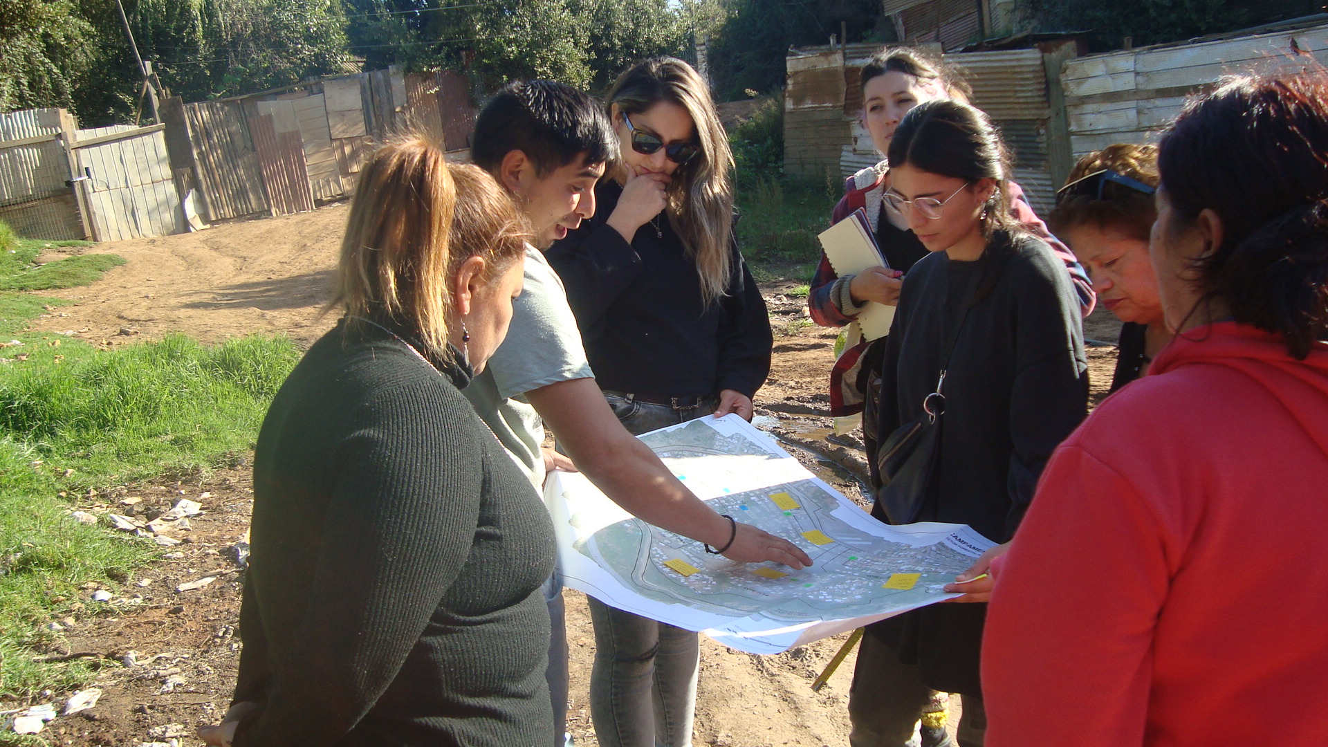 Voluntarios ISF y vecinos de la comunidad planificando el proyecto sobre un mapa